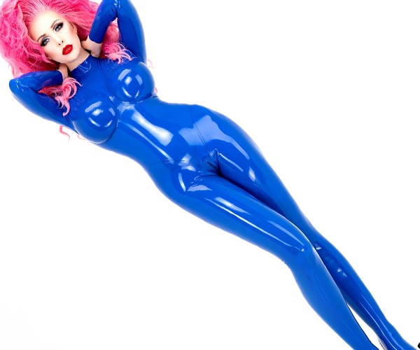 A woman wears a tight, shiny latex catsuit in blue with attached socks.