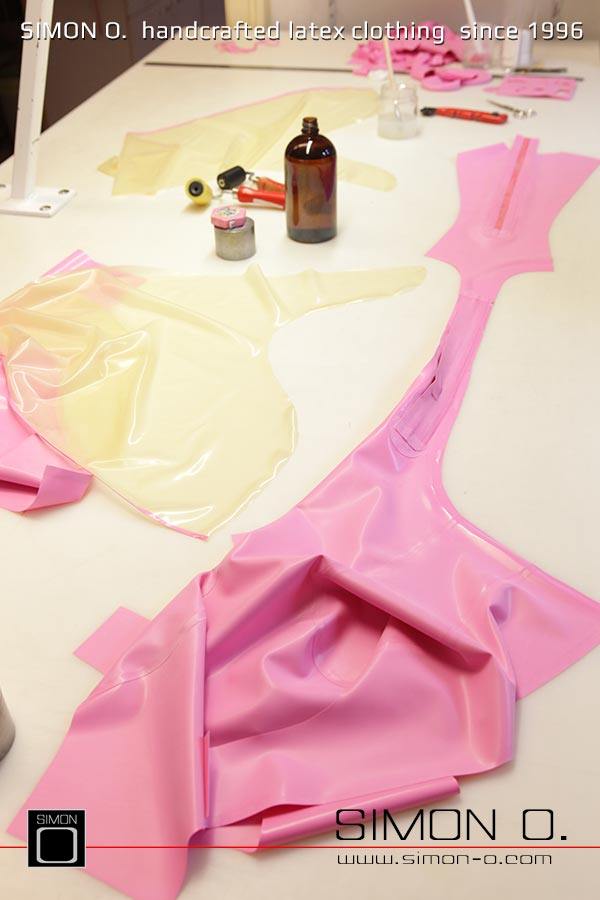 Gezeigt wird die Produktion eines Latex Catsuits in Pink mit transparenten Beinteil beginnend vom ausschneiden über das verkleben bis hin zum fertigen Produkt.