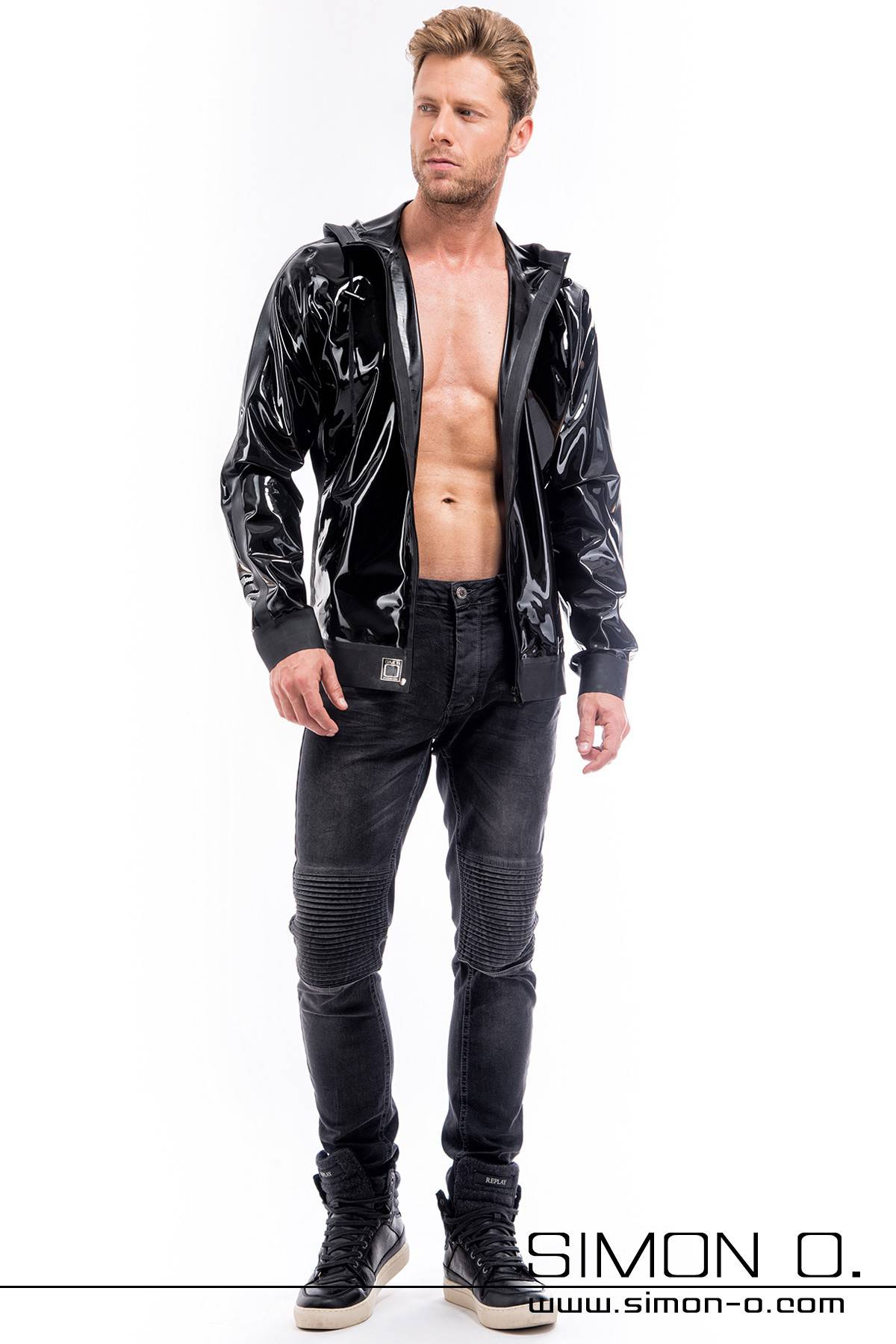 A blond man wears a latex jacket with a separable zip hood and pockets in black.