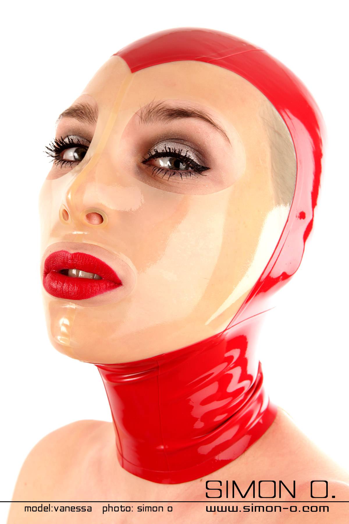 A woman wears a red latex hood with a see-through face shield