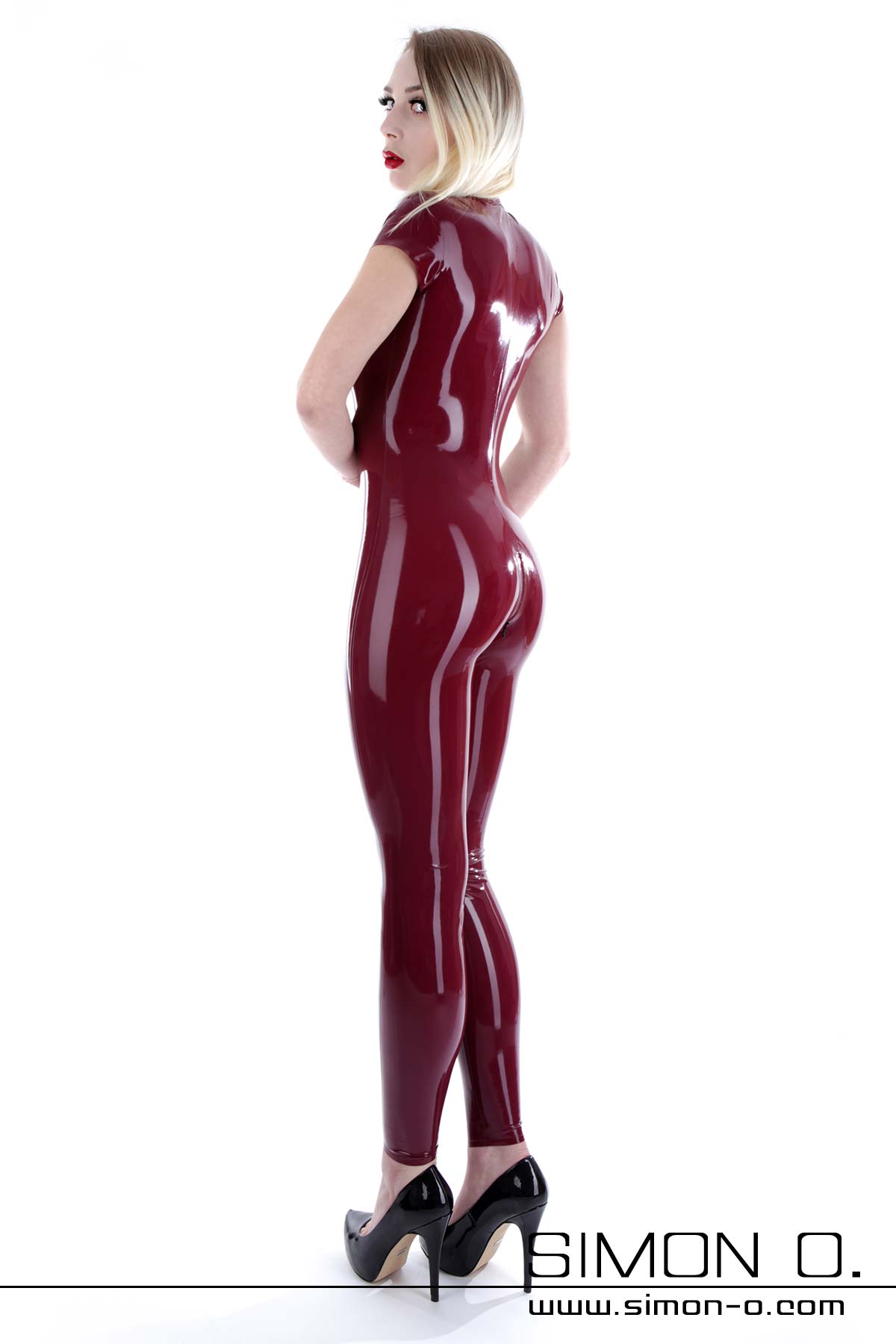 Skin tight short sleeve latex catsuit with crotch zipper seen from behind