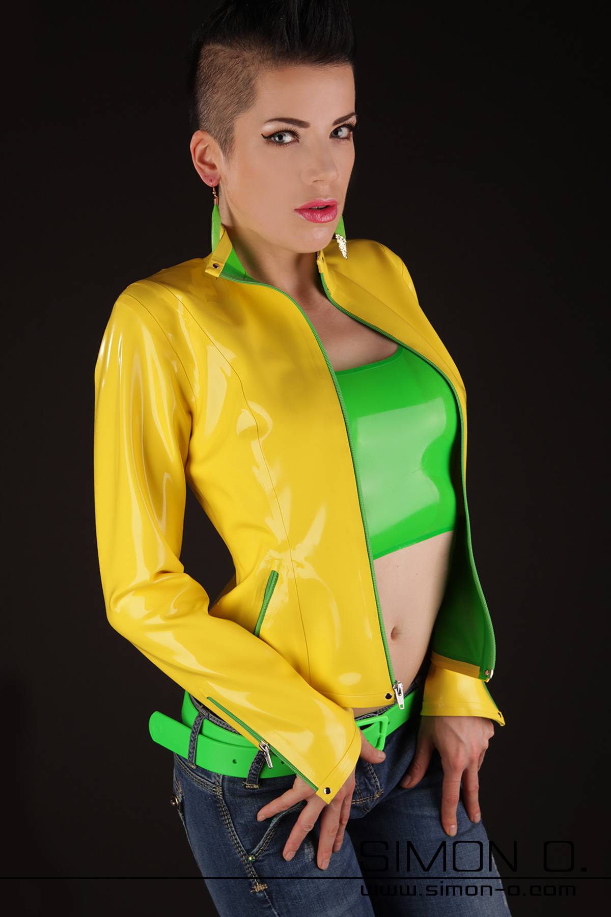 A woman in a yellow latex jacket. She wears a latex top underneath.