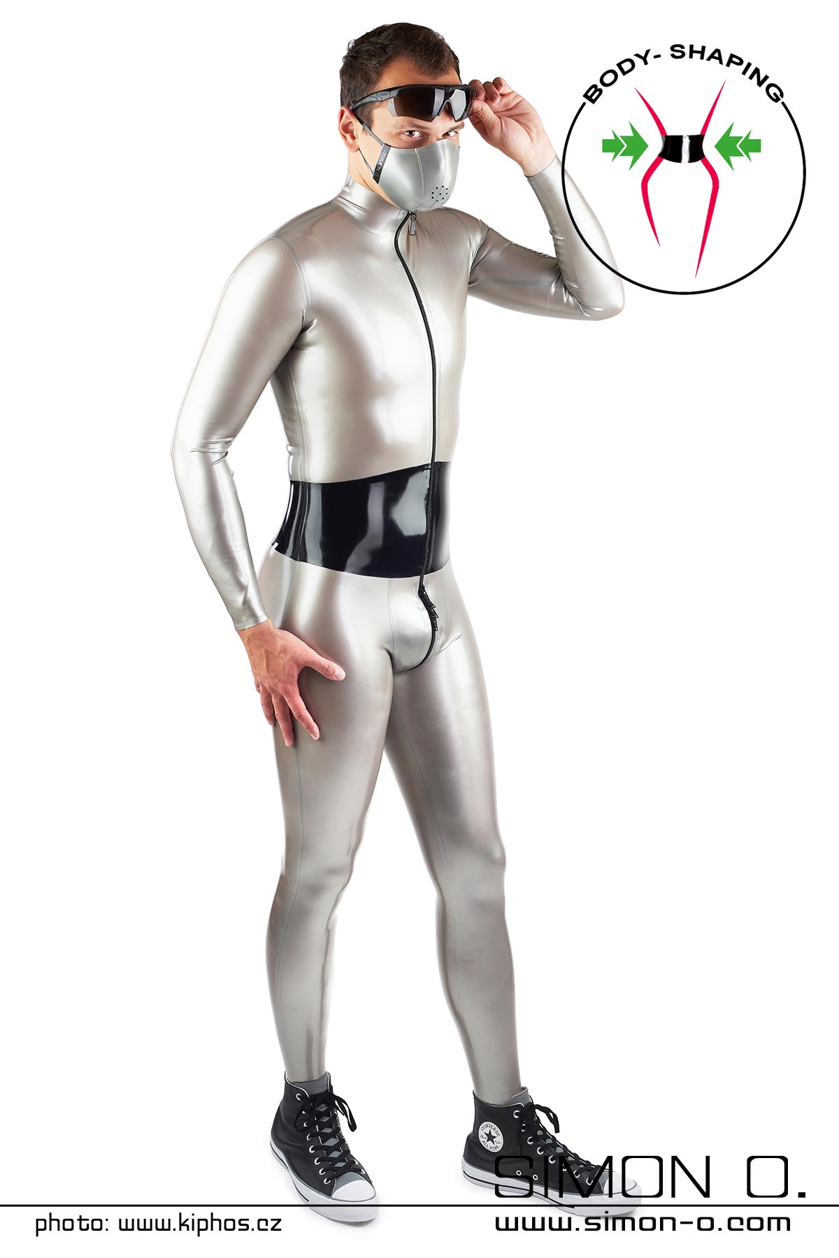 A man wears a shiny latex catsuit in silver with an integrated wide corset in black - seen from the front