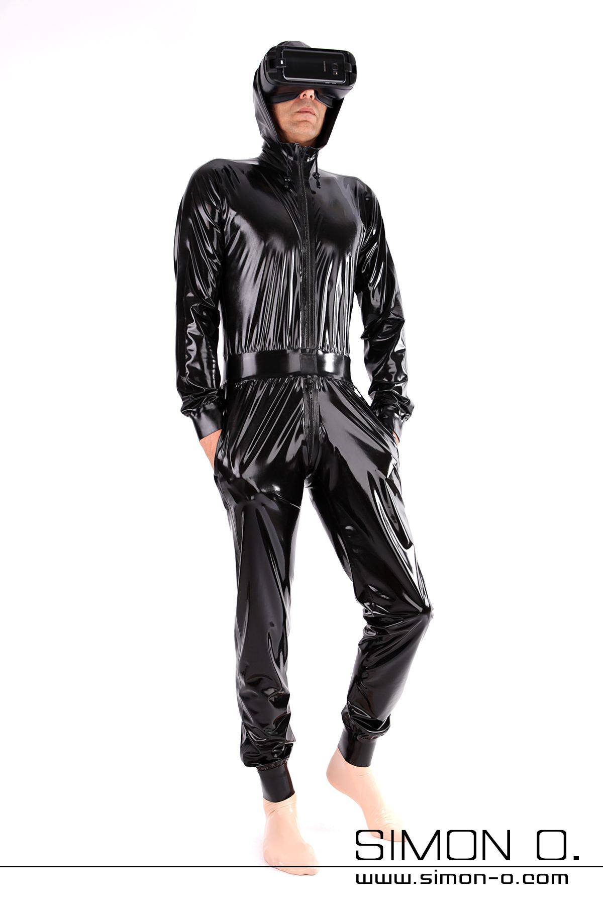 Latex Overall mit Kapuze und Taschen in Schwarz locker geschnitten aber tailliert mit Manschetten bei Armen und Beinen