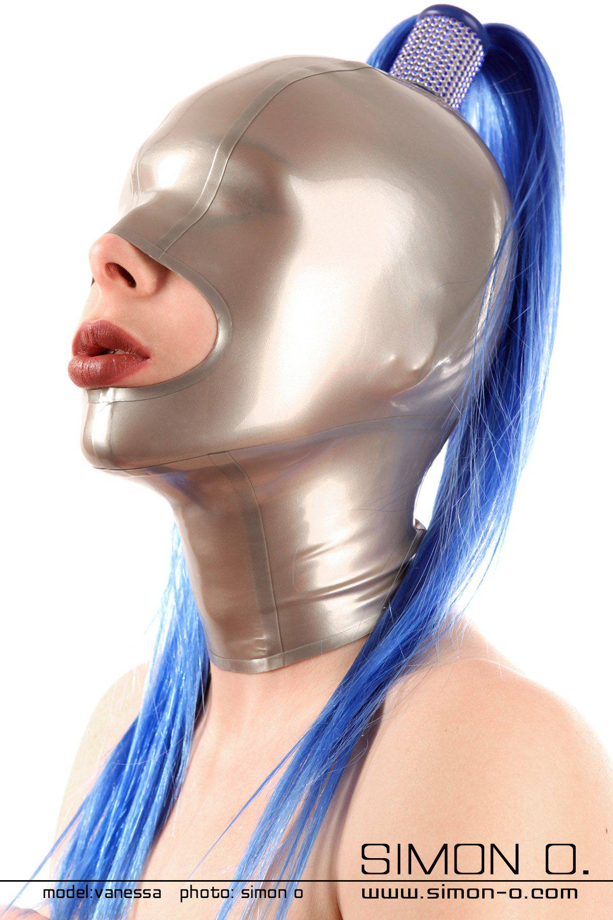 Frau mit einer Latex Maske mit Katzenaugenform und rotem Mund und Haarteil