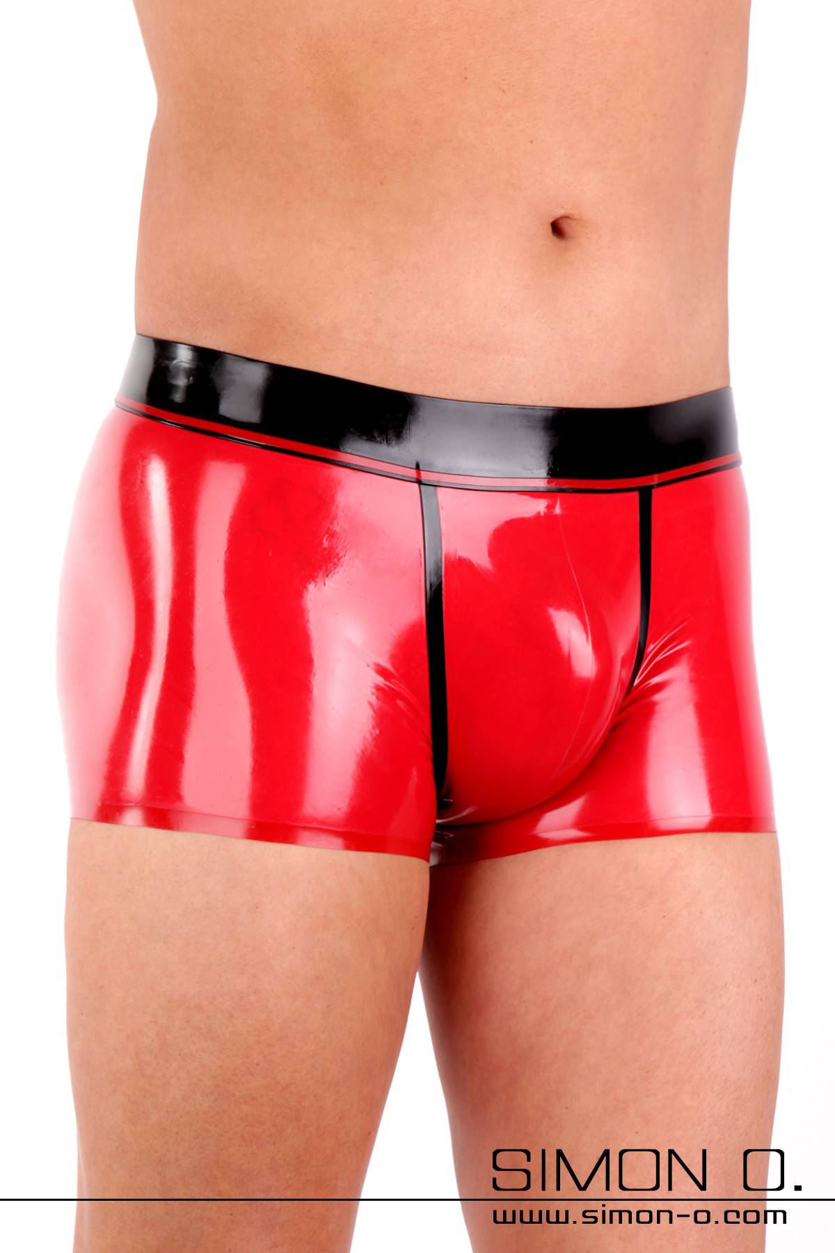 Ein Mann trägt eine hautenge glänzende Herren Latex Unterhose in Rot mit schwarzen Bund