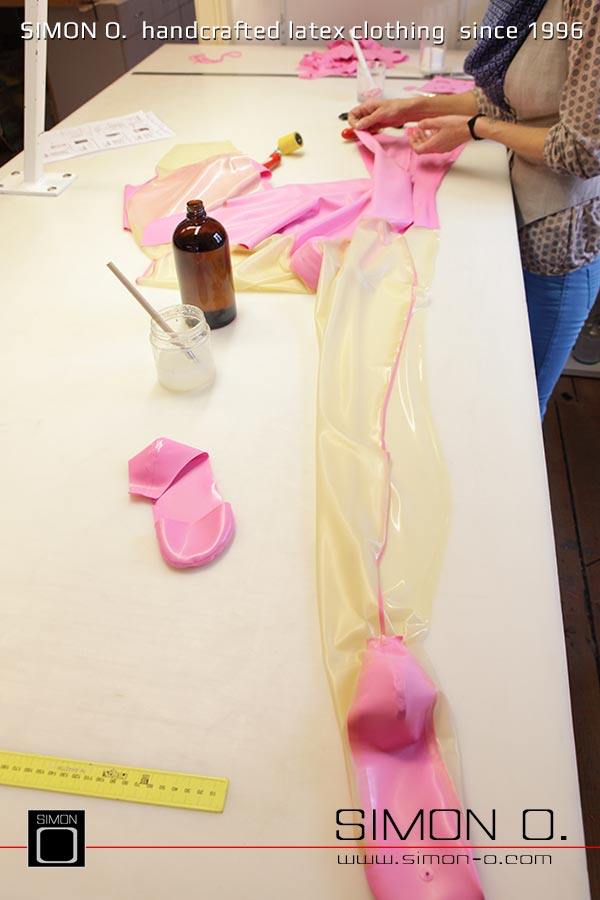 Gezeigt wird die Produktion eines Latex Catsuits in Pink mit transparenten Beinteil beginnend vom ausschneiden über das verkleben bis hin zum fertigen Produkt.