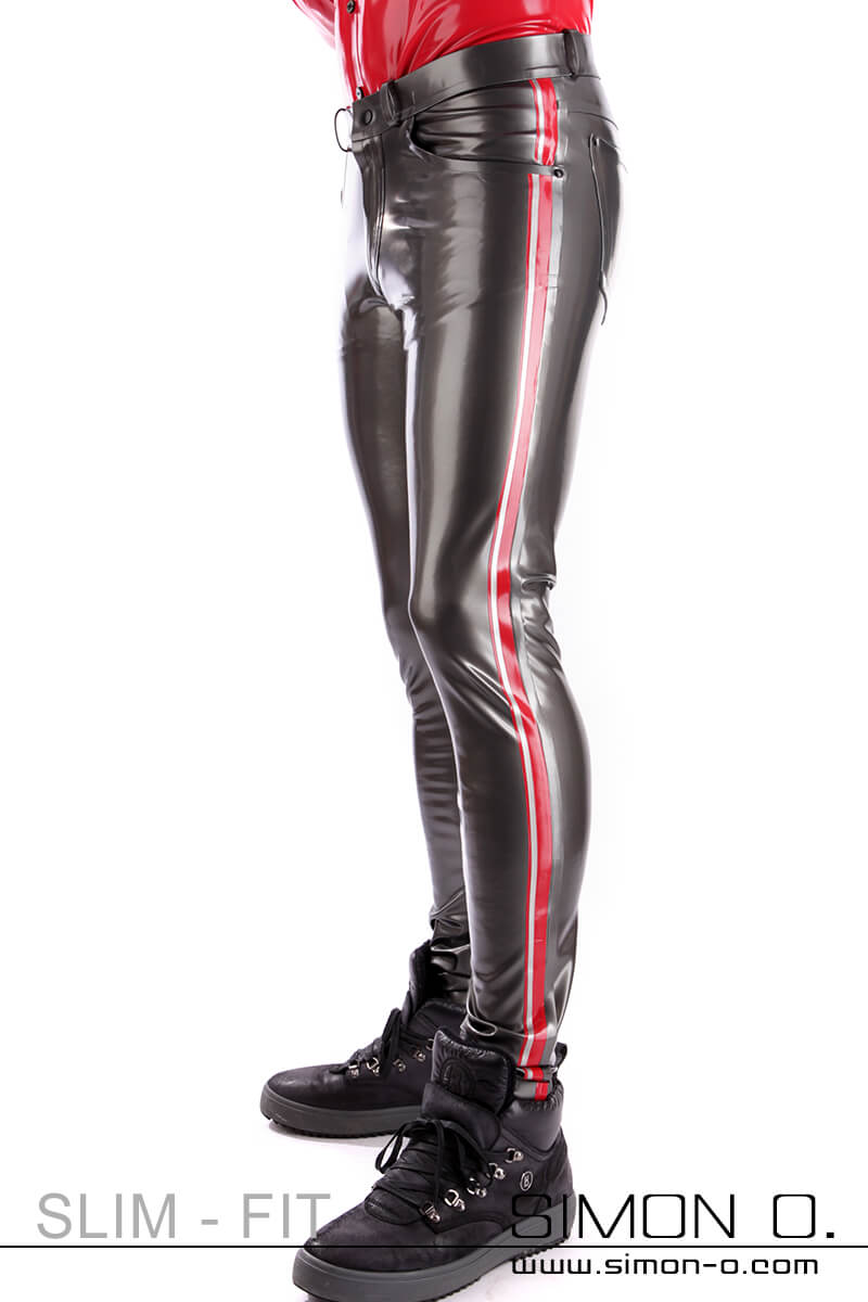 A man wears shiny dark gray latex trousers with red stripes down the sides.