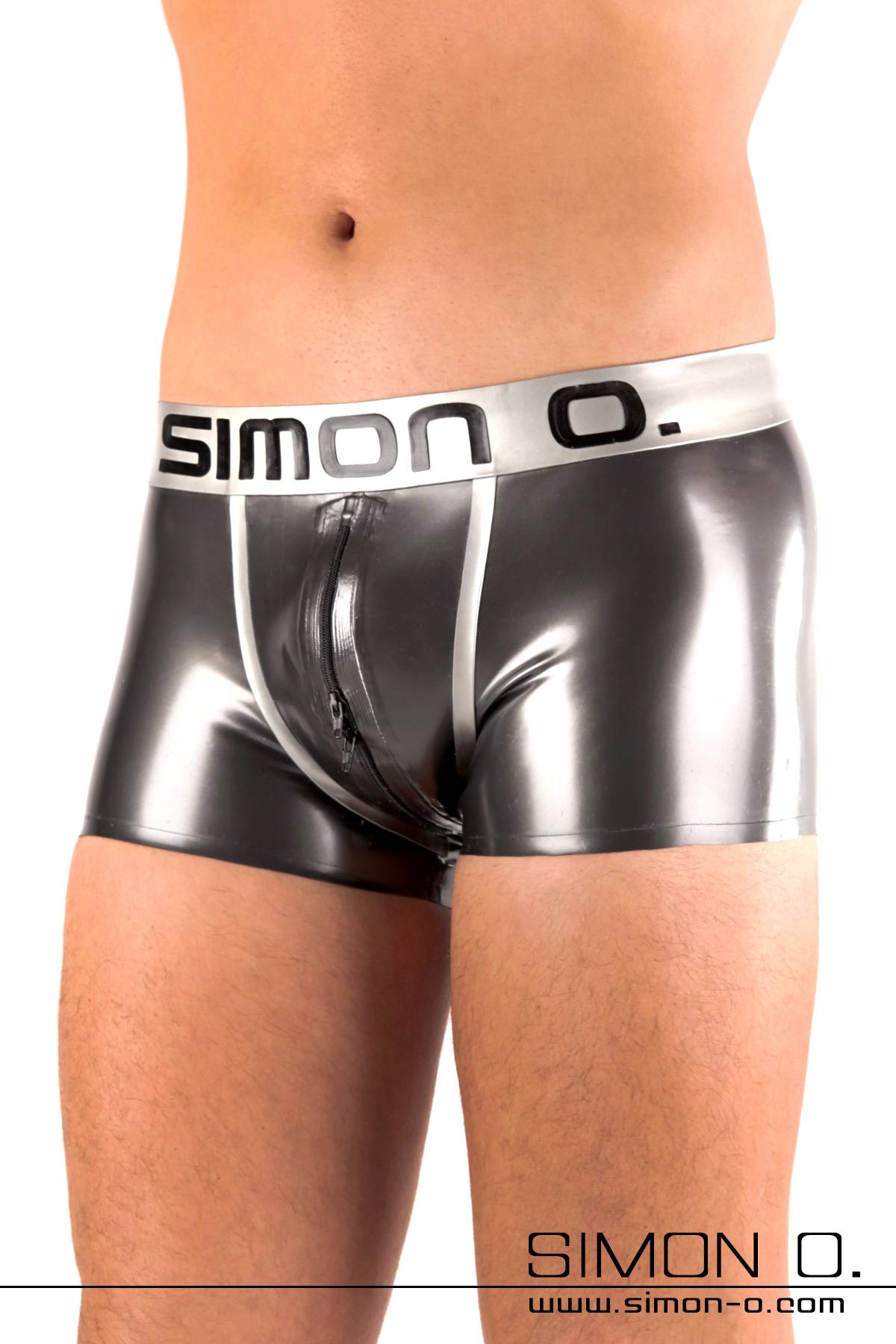 Ein Mann trägt hautenge glänzende Latex Shorts mit einem Simon O. Logo am Bund