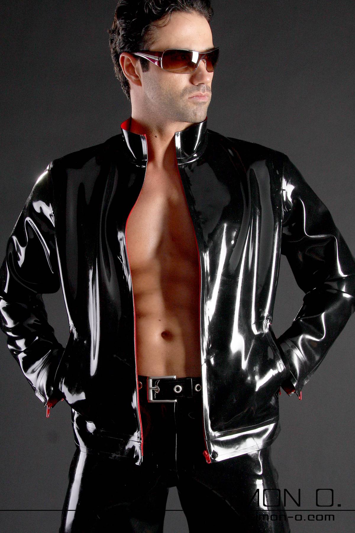 A man wearing a black shiny latex jacket with pockets