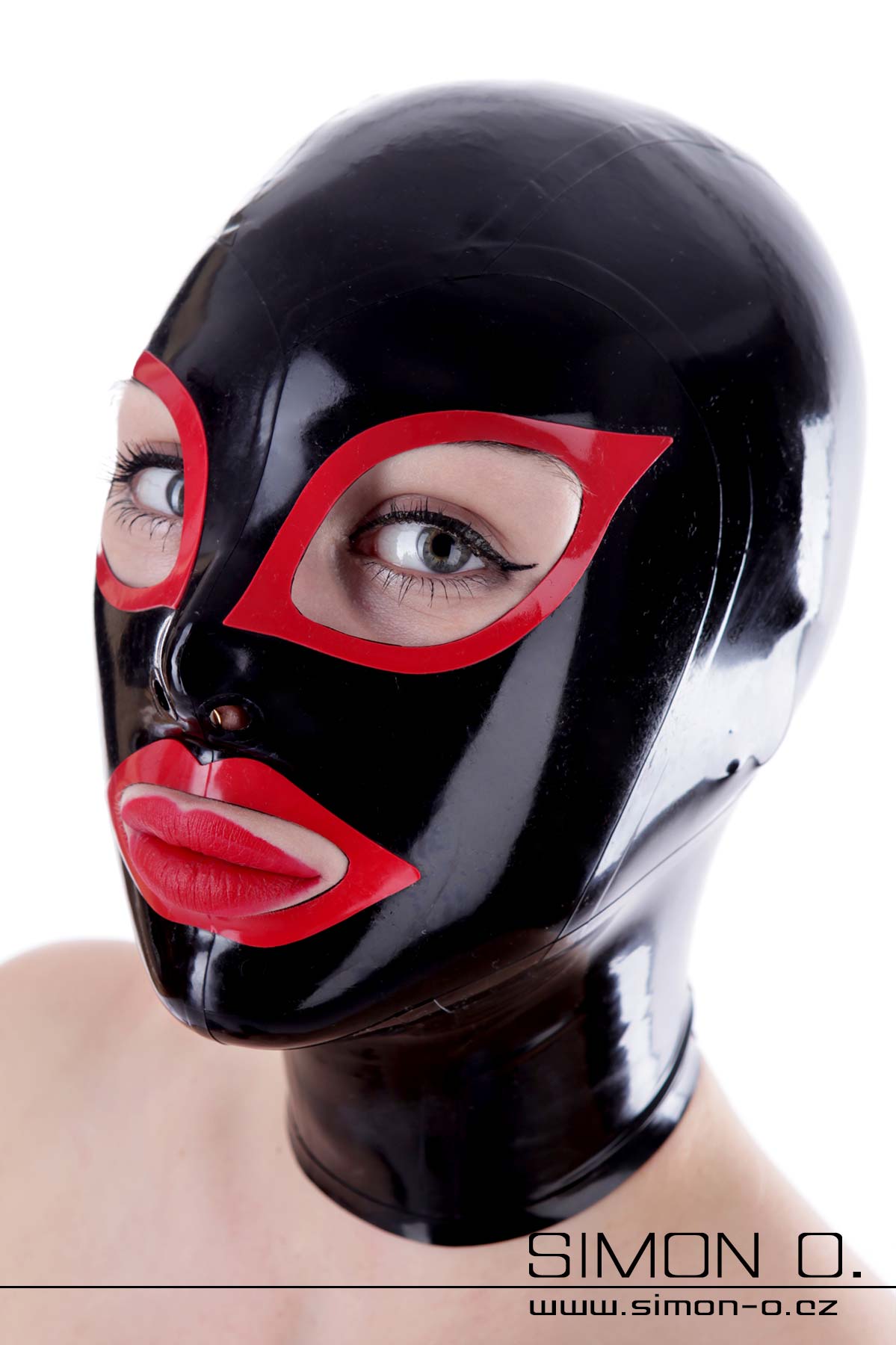 A woman wears a latex hood in black with red cat eyes and red kiss mouth.