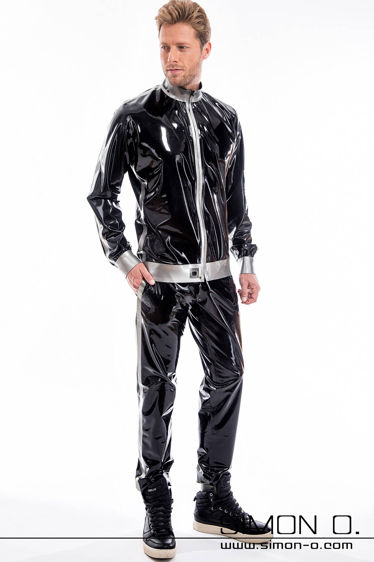 A man wearing a shiny jogging pants and a latex jacket with pockets in black combined with silver