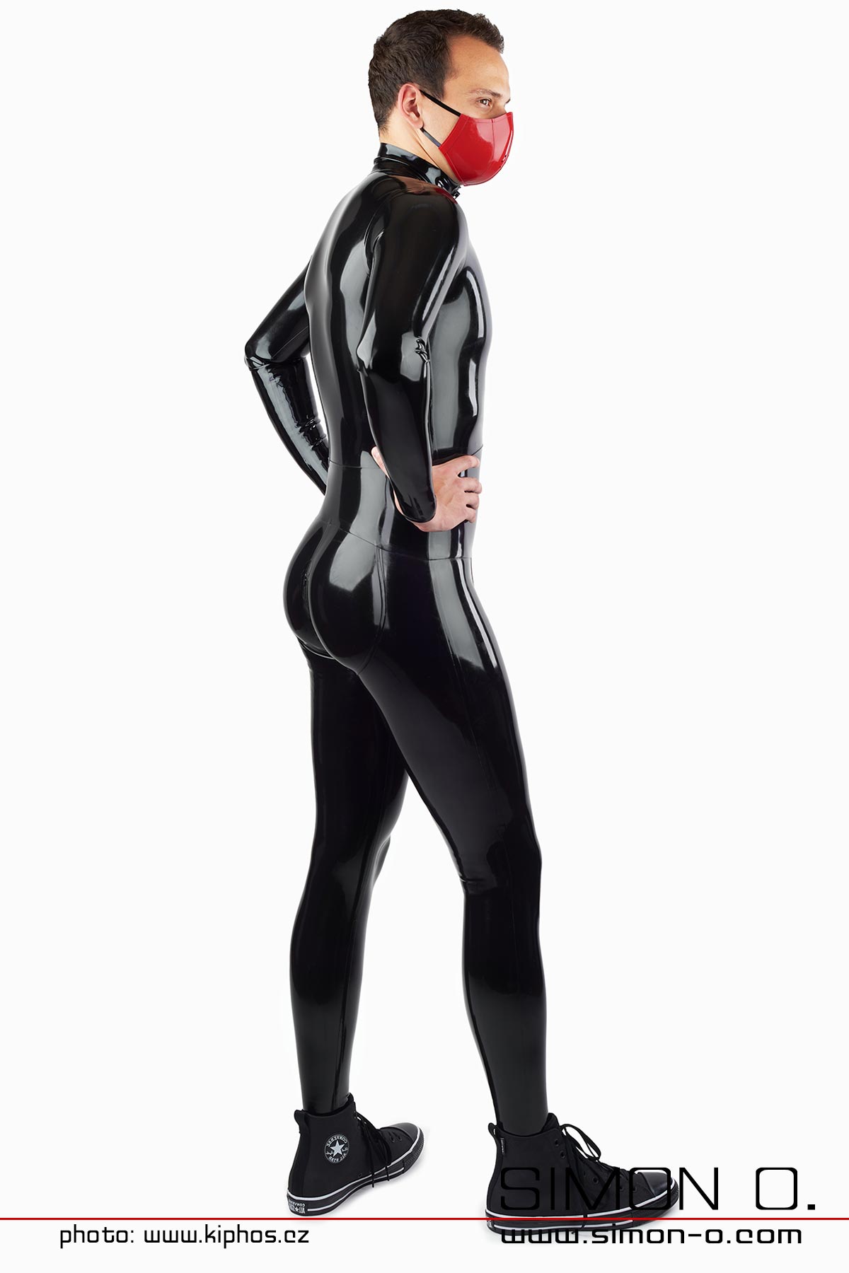 Ein Mann trägt einen engen schwarzen Latex Catsuit mit Push up Gesäßbereich