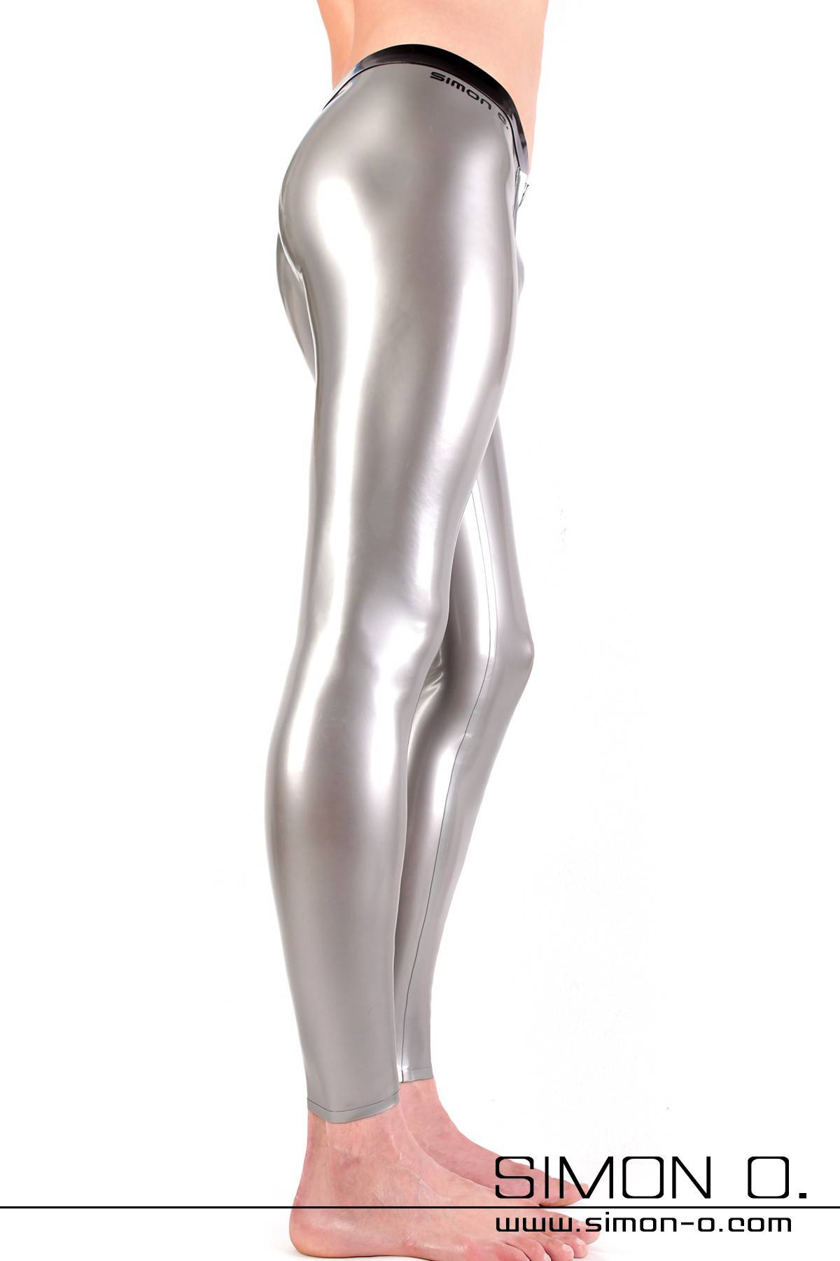 Ein Mann mit einer engen glänzenden Latex Leggings in Silber mit einen schwarzen Bund - von der Seite gesehen