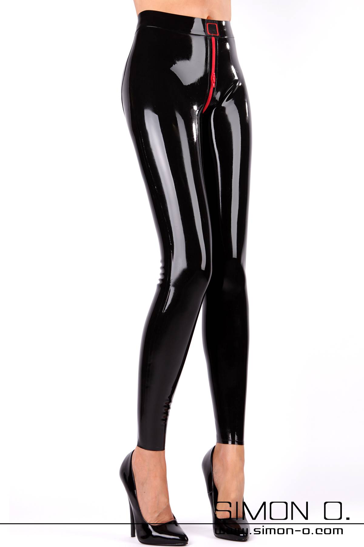 Eine Dame mit einer engen glänzenden Latex Leggings und schwarzen High Heels Die Leggings hat einen roten Zipp im Schritt