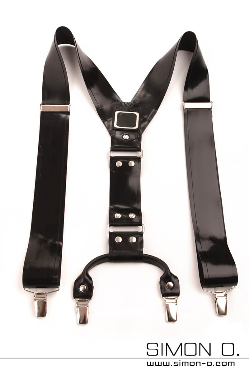 Black latex braces with silver buckles and clips lie flat on a white background. The brand name ‘Simon O.’ can be seen at the bottom of the picture.