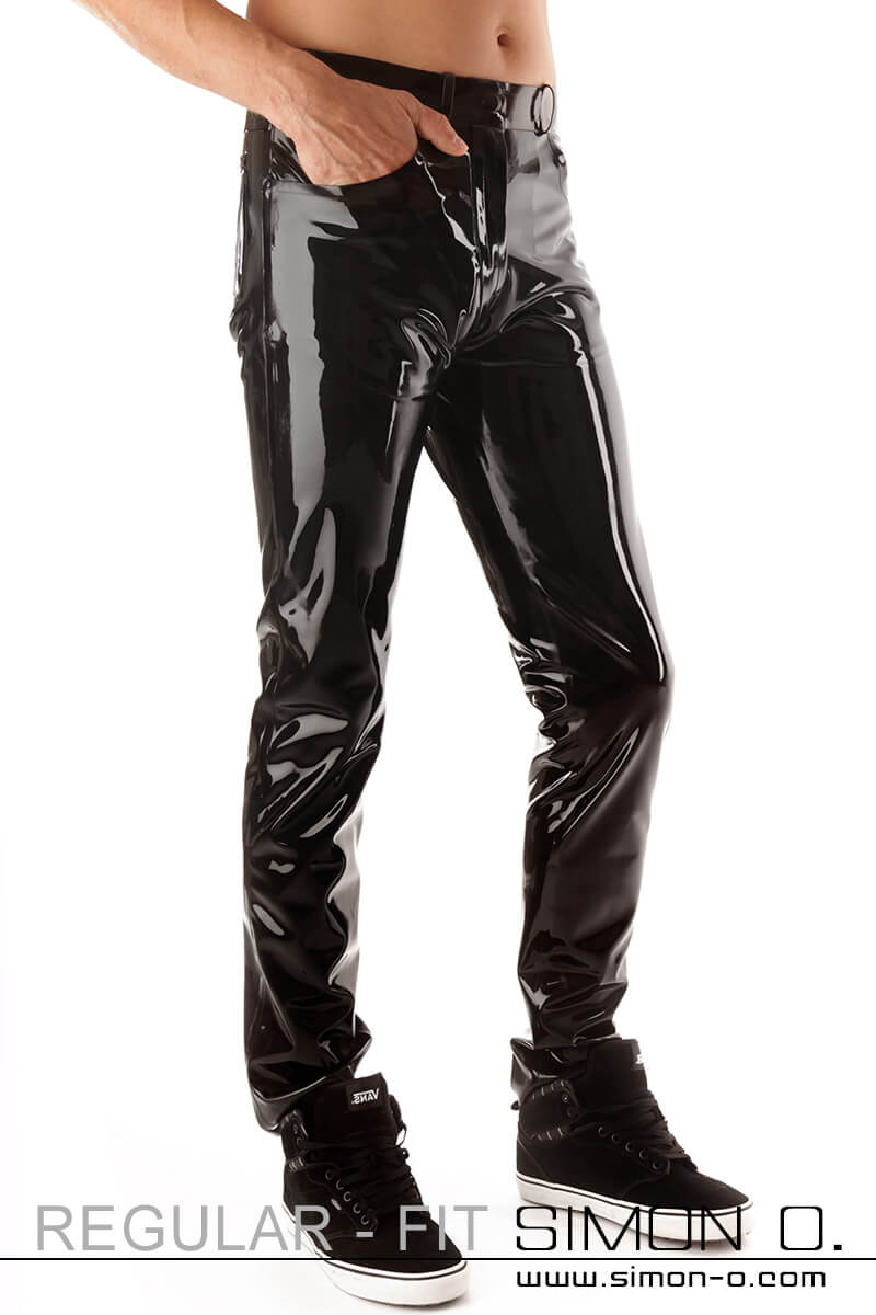 A gentleman wears a shiny latex jean and has a hand in his pocket.