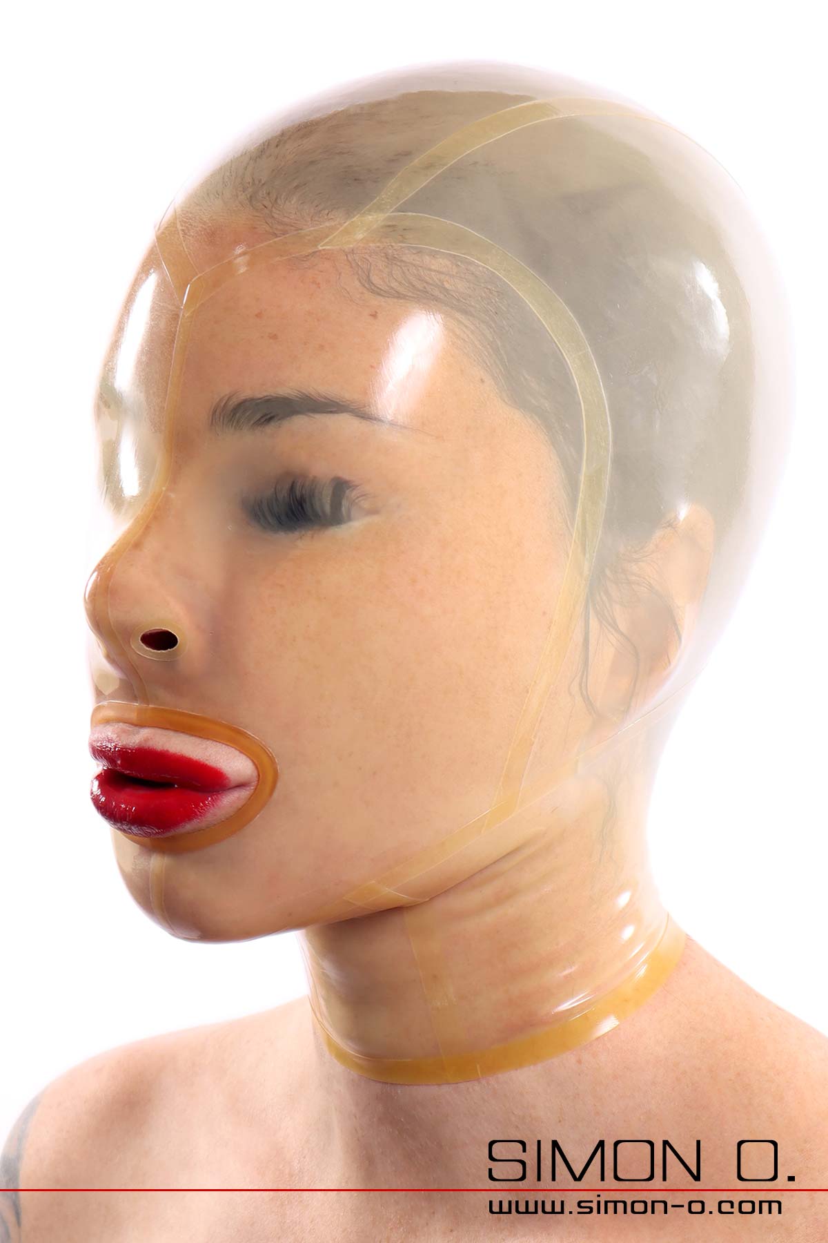 A transparent latex mask without eye openings fits snugly around the face of a woman with red lips.